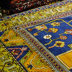 Niebiesko-żółty dywan w perskie wzory kwiatowe.